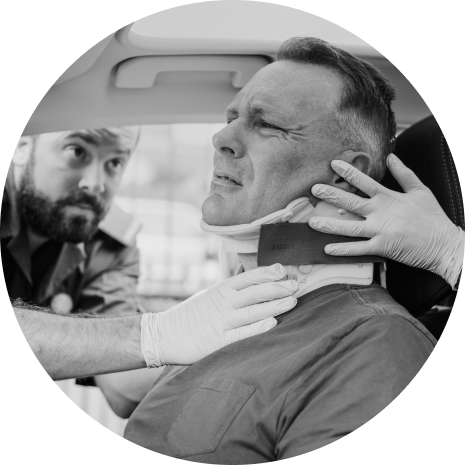 A paramedic secures a neck brace on a middle-aged man inside an ambulance after a car accident, reflecting a moment of medical attention and care.