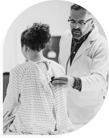 Certainly! Here's the modified description:

About a doctor in a white coat examining a female patient's back with a stethoscope in a clinical setting, both appearing focused on the procedure. The image