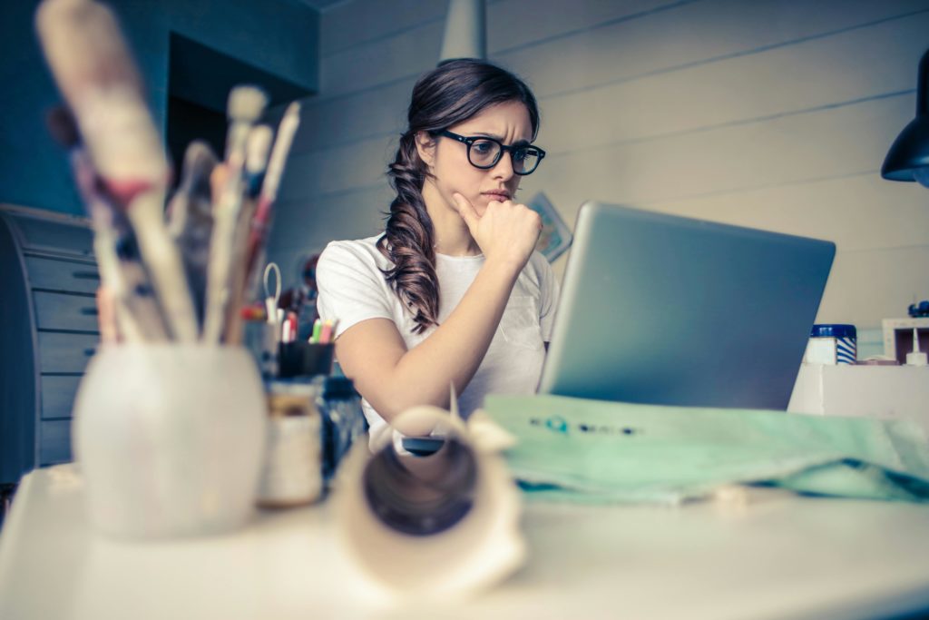 Woman at her computer thinking.