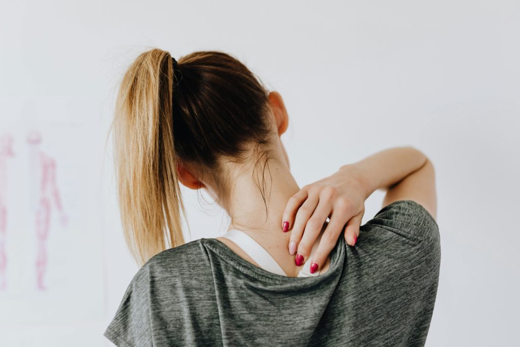 Woman holding her neck because of neck pain.