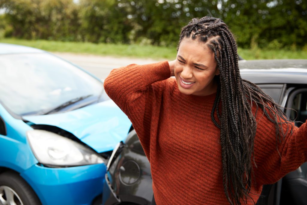 female driver holding her neck after a car accident