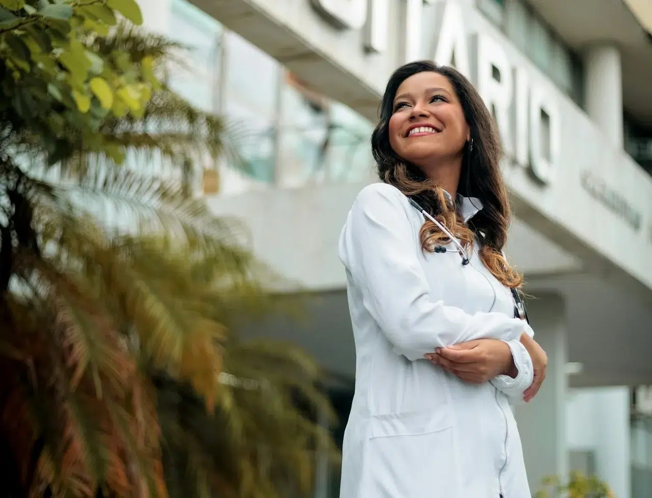 Female medical professional standing confidently outside a clinic, representing auto accident doctor care, urgent care after car accident, and after accident care services.